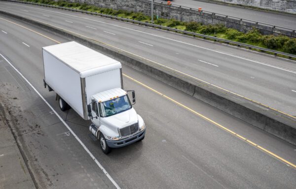 White box truck driving on highway.